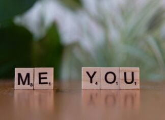 Free Spell to Make Him Text Me Right Now (Works Within Hours) Close-up of Scrabble tiles spelling 'Me You' symbolizing love and connection on a wooden table. - free spell to make him text me right now