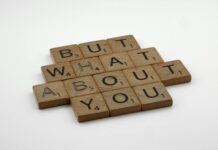 Make Him Think About You Constantly: The Ancient Mirror Technique That Never Fails Close-up of wooden Scrabble tiles spelling 'But What About You' on a white surface. - make him think about me constantly spell