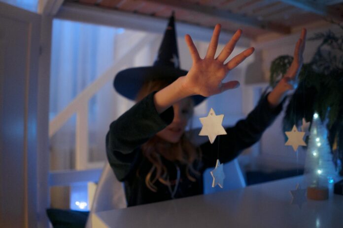 A child dressed as a wizard conjuring stars indoors, capturing a magical and imaginative moment. - obsession spell
