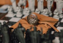Powerful Binding Love Spells for Marriage A steampunk clock rests on a leather-bound notebook with chess pieces in the background, evoking a magical atmosphere. - binding love spells